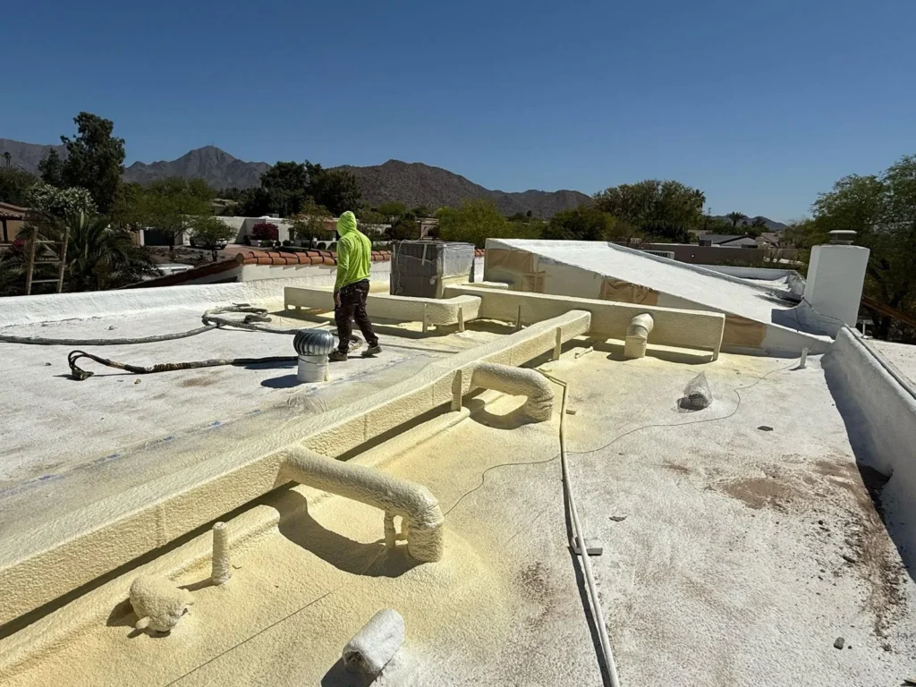 Roofing Contractor in Scottsdale, AZ Inspecting Flashing Along a Residential Parapet Wall